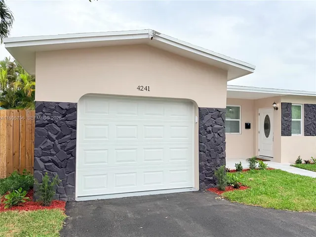 a front view of a house with a garden and plants