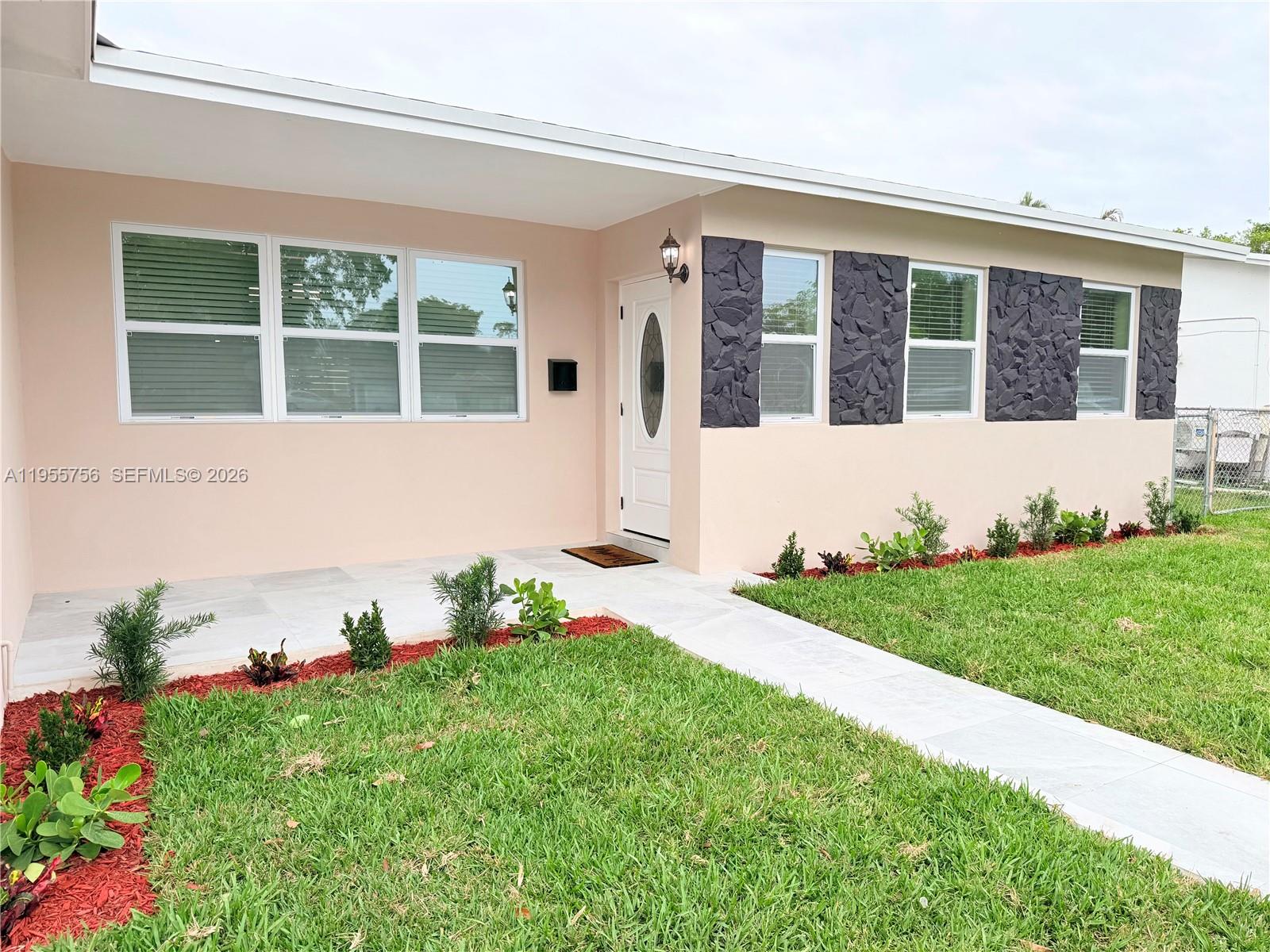4241 Thomas Street Hollywood, FL 33021 - Photo 5 of 91 a front view of a house with a garden and plants