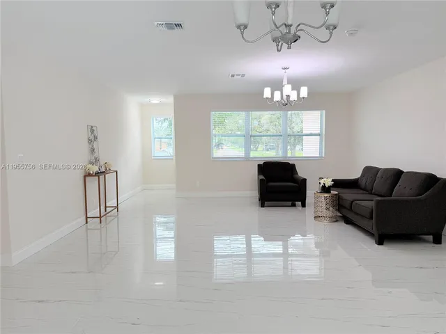 a living room with furniture a lamp and a chandelier