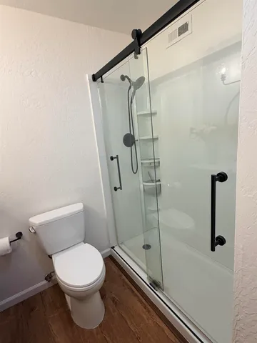 a bathroom with a toilet and a shower