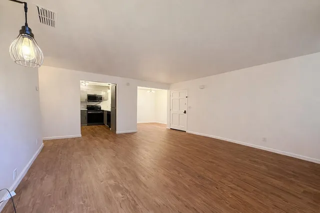 a view of empty room with wooden floor