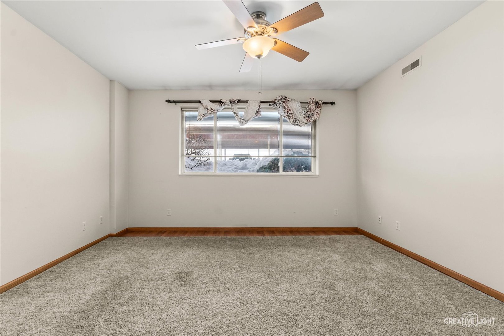 575 North Strack Street, Unit 103 Cortland, IL 60112 - Photo 4 of 11 an empty room with a window and a fan
