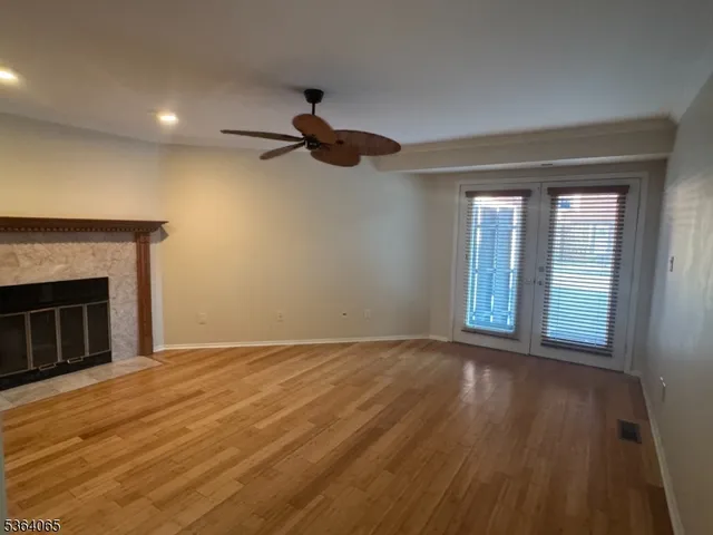 a view of an empty room with a fireplace and a window