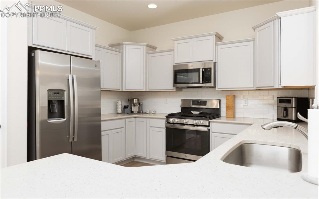 4031 Samaritan Loop Colorado Springs, CO 80916 - Photo 5 of 34 a kitchen with stainless steel appliances granite countertop a refrigerator sink and stove
