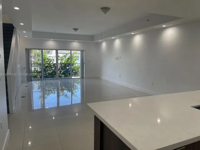 a view of an empty room with a kitchen