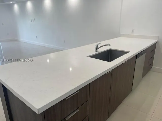 a kitchen with a sink and white cabinets