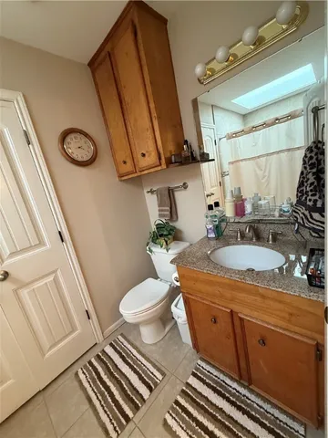 a bathroom with a granite countertop sink a toilet a mirror and shower