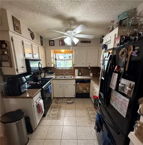 a kitchen with a sink appliances cabinets and a window