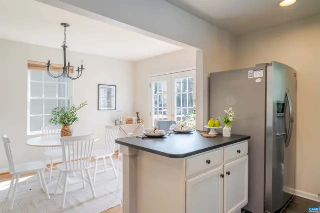 a kitchen with stainless steel appliances granite countertop a refrigerator a sink a stove and white cabinets