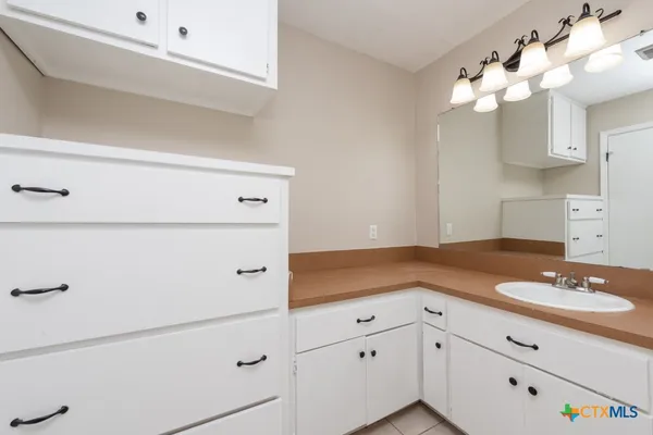 a bathroom with a sink vanity and mirror