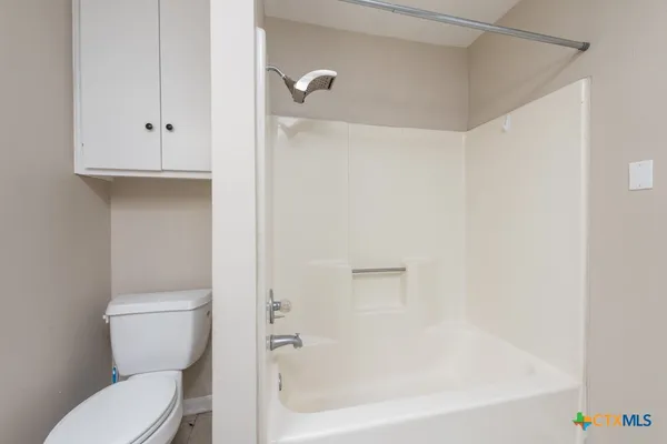 a white toilet sitting next to a bath tub