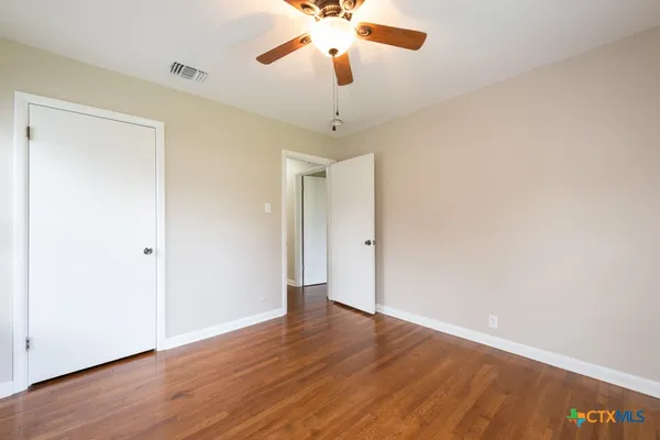 a view of an empty room with wooden floor