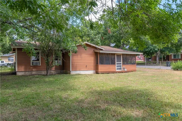 a front view of house with yard barbeque and outdoor seating