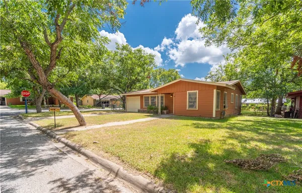 a view of a house with backyard and tree