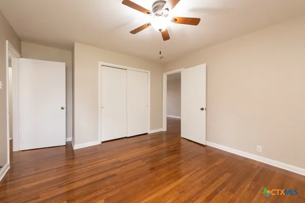 a view of an empty room with wooden floor