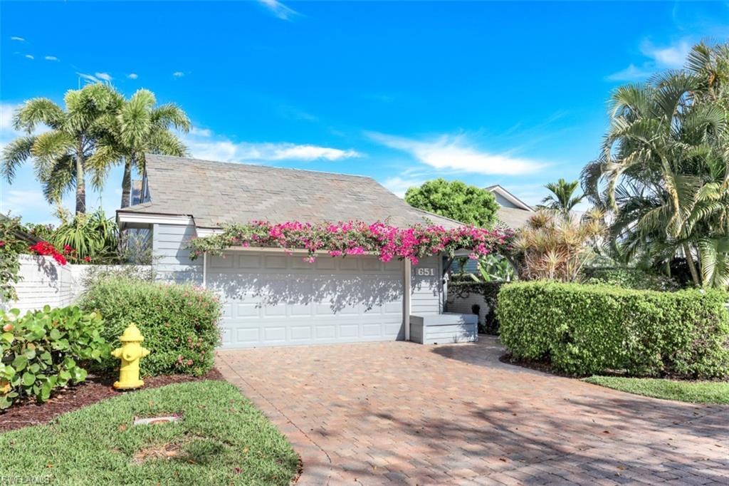 651 Bridge Way Lane, Unit 143 Naples, FL 34108 - Photo 2 of 27 a front view of a house with a yard and a garage