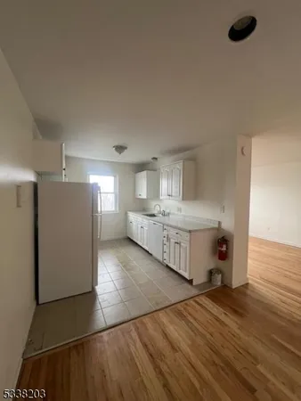 a view of a kitchen with a sink and a refrigerator