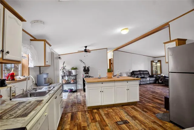 a kitchen with granite countertop a sink stove and refrigerator