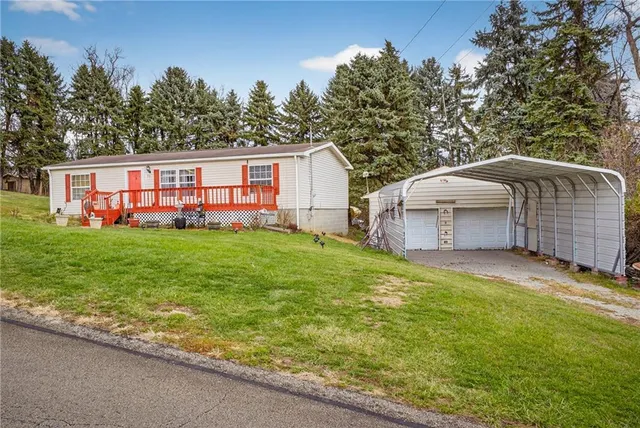 a view of a house with a yard and sitting area