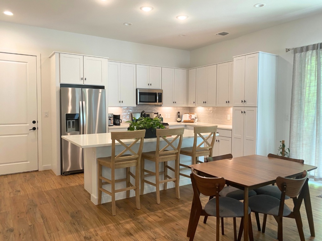 Kitchen with modern appliances, quartz countertops and space for dining and entertaining.