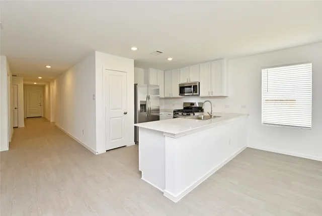 a kitchen with stainless steel appliances white cabinets and a refrigerator