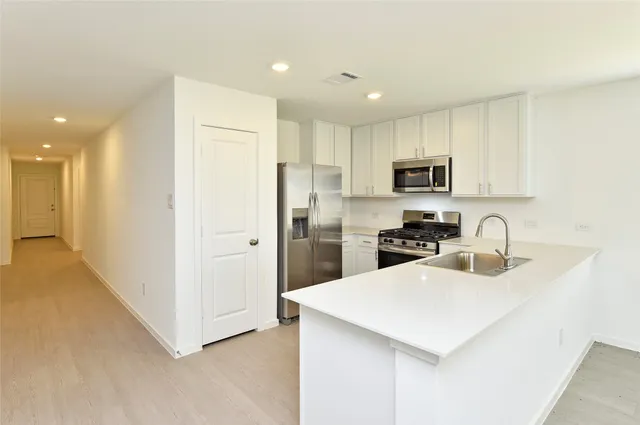 a kitchen with a sink a stove a refrigerator a center island and cabinets