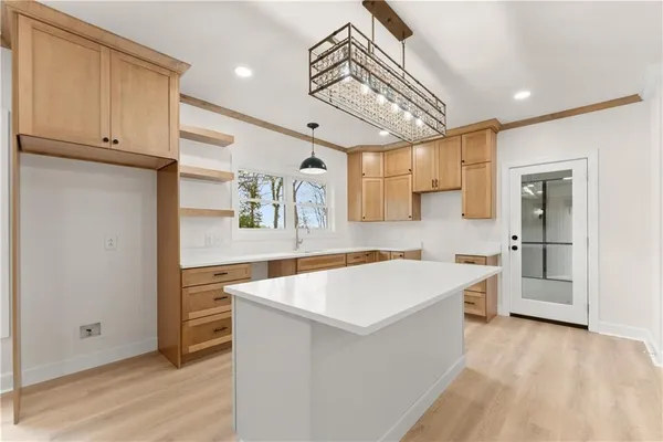 a kitchen with a white wooden cabinets and a window