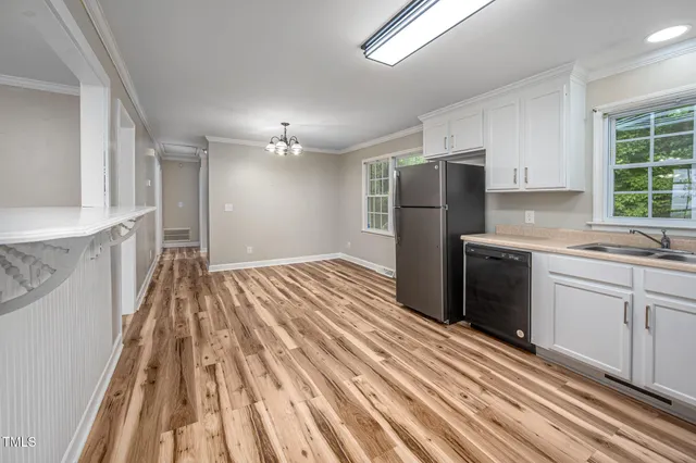 a kitchen with a sink a refrigerator and cabinets