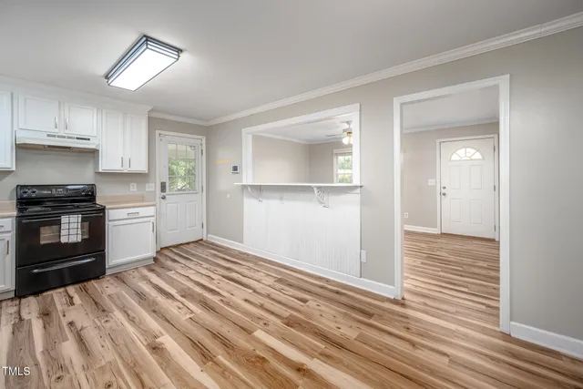 a kitchen with granite countertop white cabinets and appliances