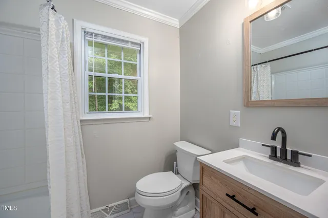 a bathroom with a sink a toilet and a window
