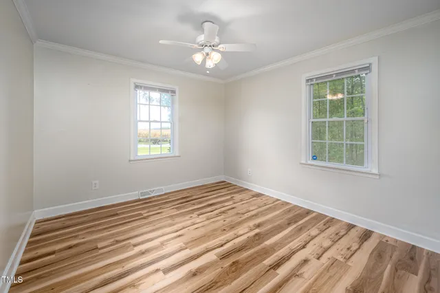 a view of a bedroom with a window and a ceiling fan