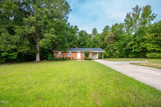 a front view of a house with yard and green space