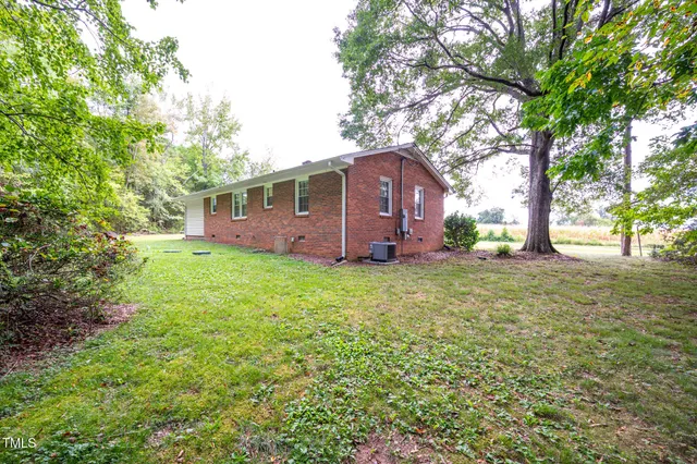 a view of backyard with a garden and large trees