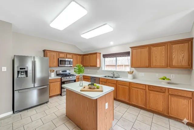a kitchen with a sink stainless steel appliances and counter space