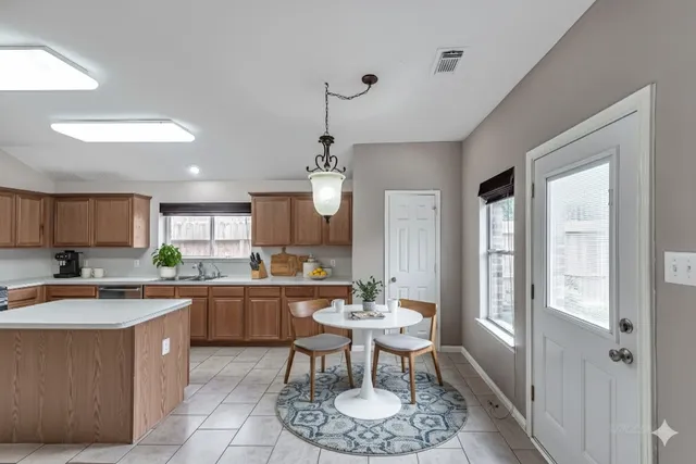 a kitchen with a dining table chairs sink and stove
