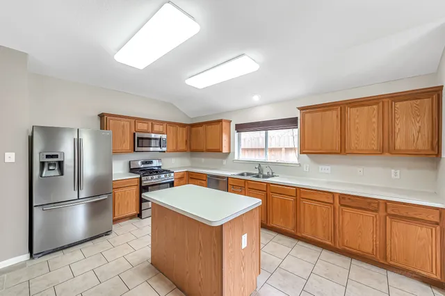 a kitchen with stainless steel appliances granite countertop a sink stove and refrigerator
