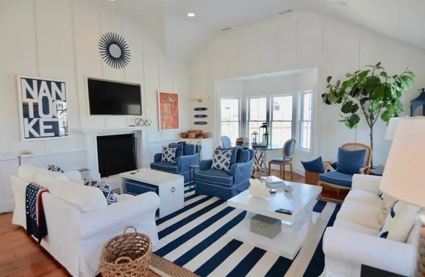 a living room with furniture a flat screen tv and a fireplace