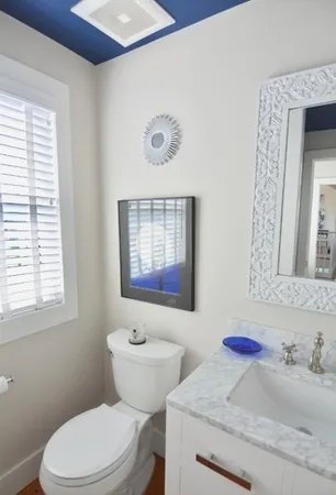 a bathroom with a granite countertop toilet sink and mirror