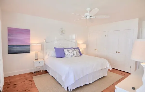 a bedroom with a bed and a ceiling fan