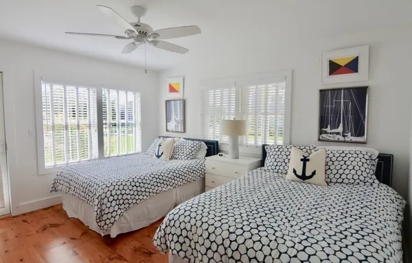 a bedroom with two beds and windows