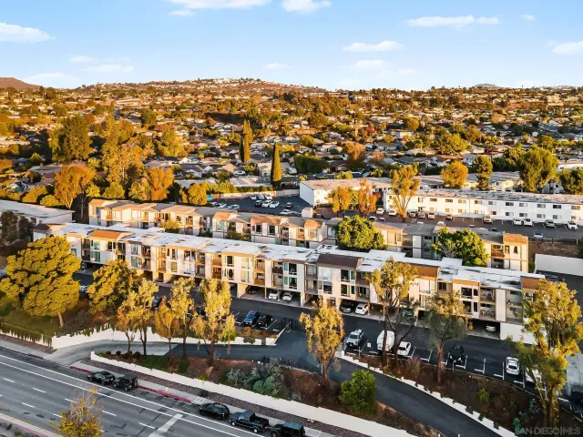 a city view with tall buildings and cars parked