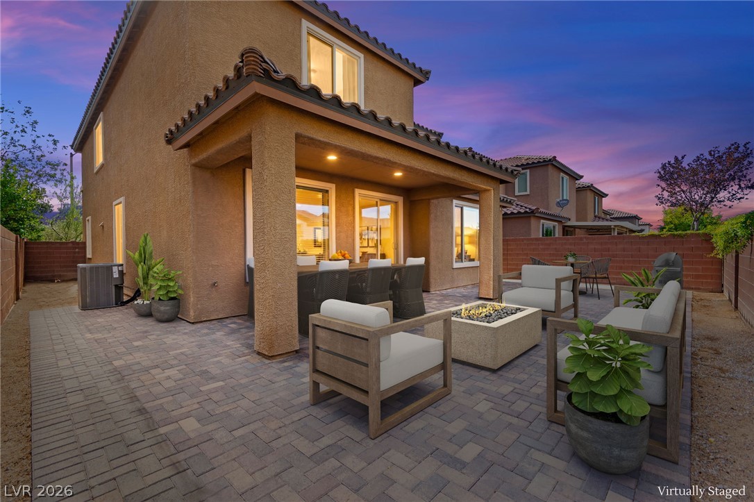 11048 Prairie Grove Road Las Vegas, NV 89179 - Photo 2 of 75 An inviting paved patio with a fire pit offers a serene outdoor living space.