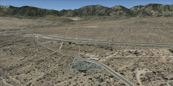 a view of a dry yard with mountain view