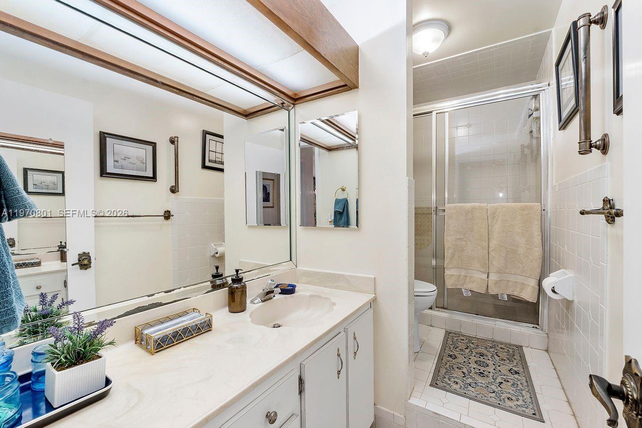 4905 Southwest 71st Place Miami, FL 33155 - Photo 29 of 37 a bathroom with a sink a glass door shower and a mirror