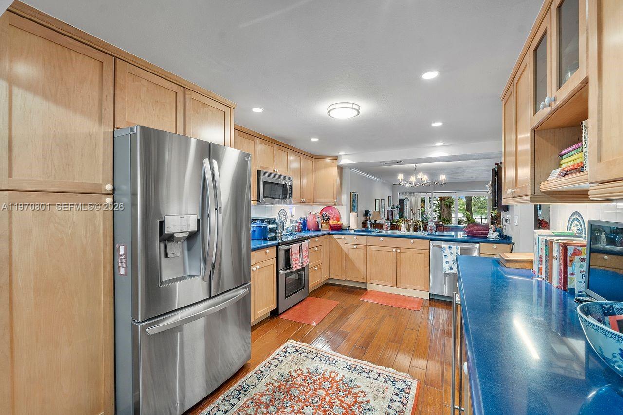 4905 Southwest 71st Place Miami, FL 33155 - Photo 9 of 37 a kitchen with stainless steel appliances a refrigerator a stove top oven and a center island