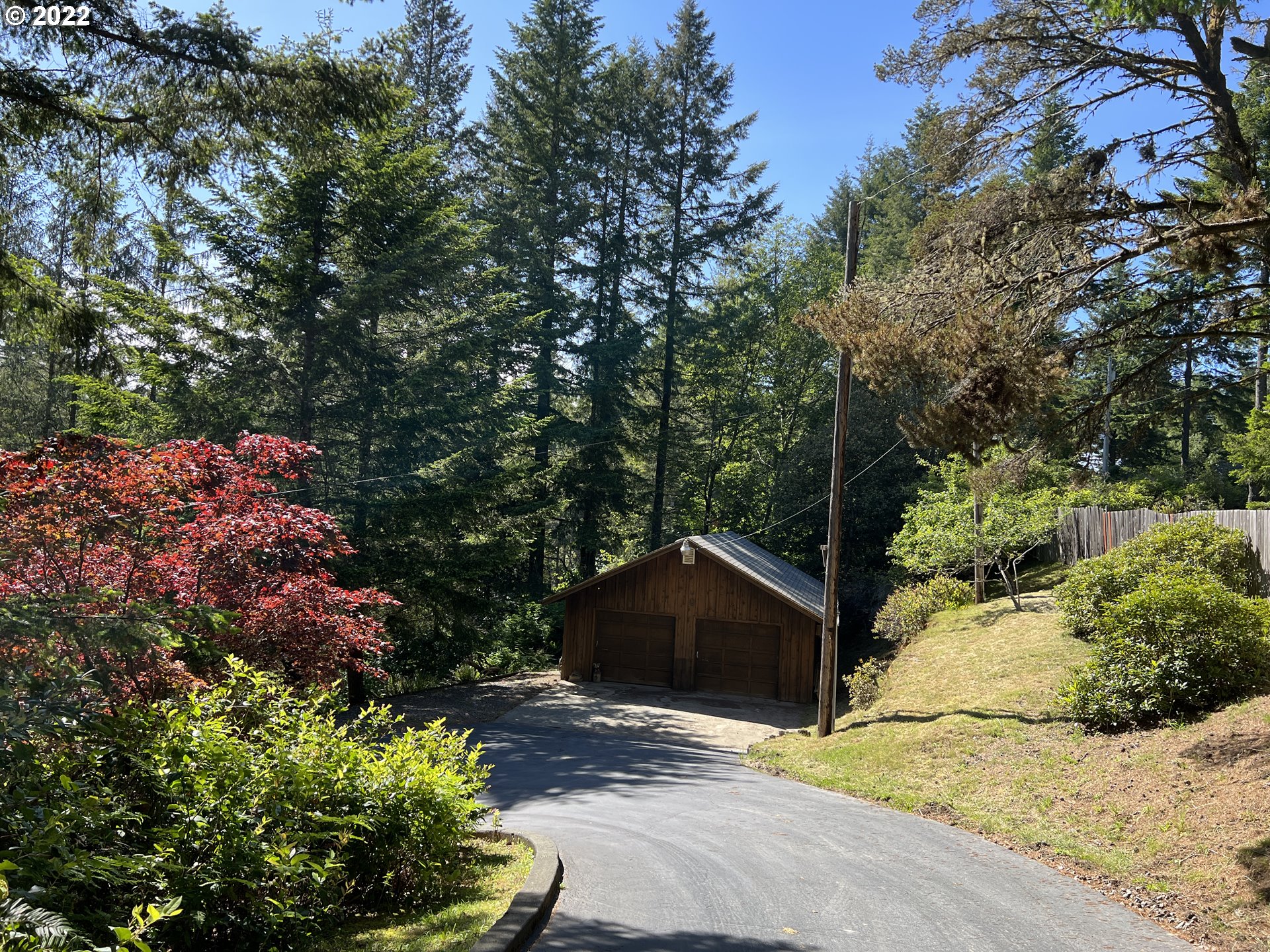 96068 Sundown Road Brookings, OR 97415 - Photo 17 of 31 a view of a wooden house with a yard and large trees