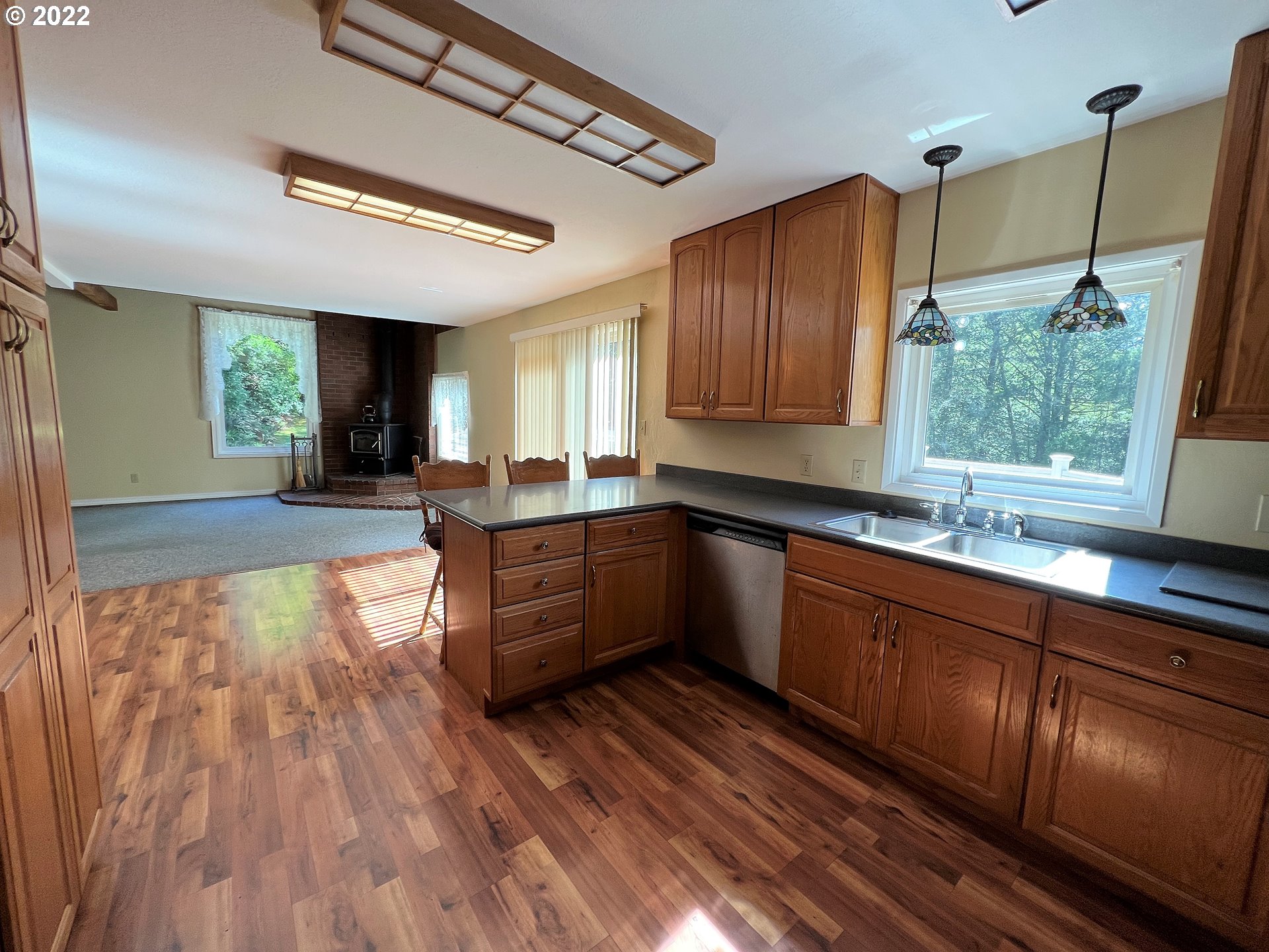 96068 Sundown Road Brookings, OR 97415 - Photo 5 of 31 a large kitchen with wooden floors and stainless steel appliances