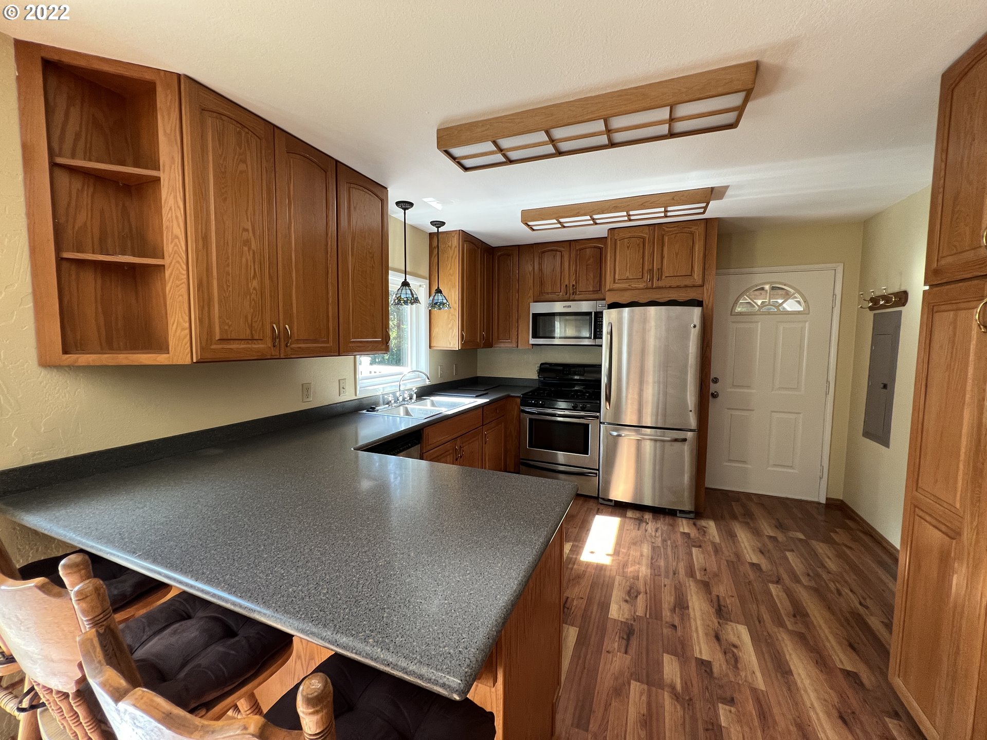 96068 Sundown Road Brookings, OR 97415 - Photo 6 of 31 a kitchen with stainless steel appliances a refrigerator and wooden floor