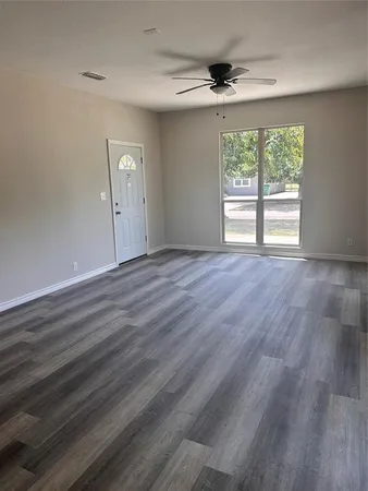 wooden floor in an empty room with a window