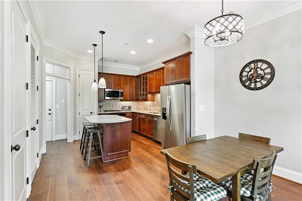 3635 East Paces Circle, Unit 1410 Atlanta, GA 30326 - Photo 12 of 68 a kitchen with stainless steel appliances granite countertop a refrigerator a sink dishwasher a stove and a dining table with wooden floor